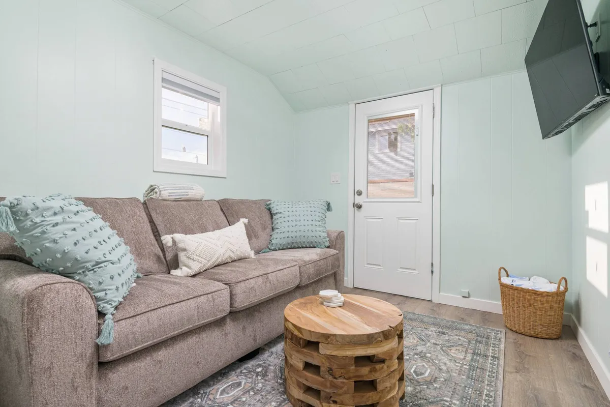 A cozy living area featuring a comfortable sofa, a stylish coffee table, and a doorway that may lead toward the outdoor space. The setting is inviting, perfect for relaxing after a day of adventure, and subtly hints at a transition between indoor relaxation and outdoor enjoyment.
