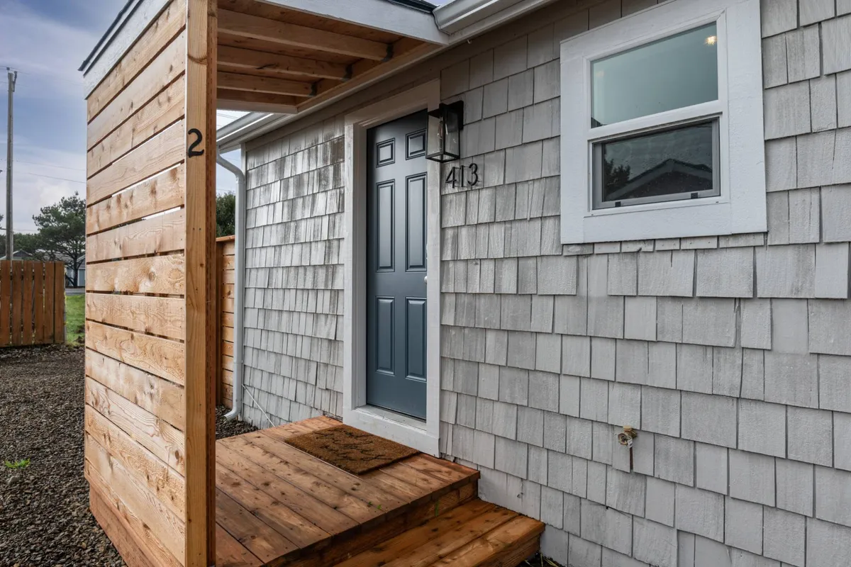 A charming wooden porch and front door offer a sense of seclusion and warmth, suggesting a home that's ready to welcome guests into its relaxing ambiance.